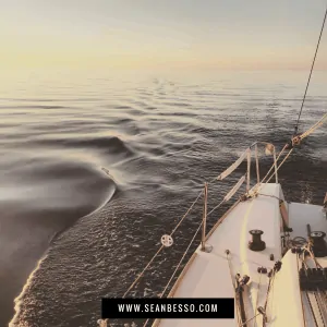 sail boat on smooth water at sunset